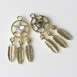 Close-up of golden dreamcatcher charms with heart rhinestones and feather pendants