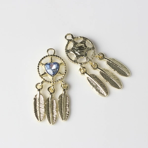 Detail of golden dreamcatcher charms with blue heart crystal and feather pendants