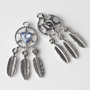Detailed view of silver dreamcatcher charms with blue heart crystal and metal feathers