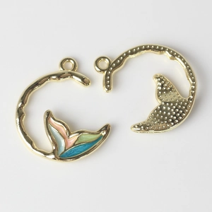 Macro detail of alloy fishtail charms showing enamel finish and textured metal back