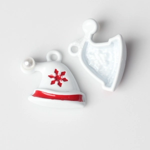 Detail van kerstmuts bedeltjes van legering met parel, rode ster en afwerking met olie