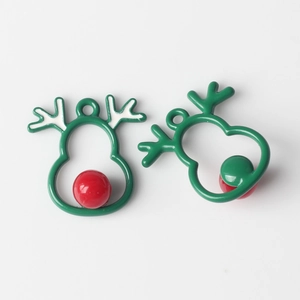 Detalle de colgantes de reno esmaltados en verde con perlas rojas para joyería artesanal