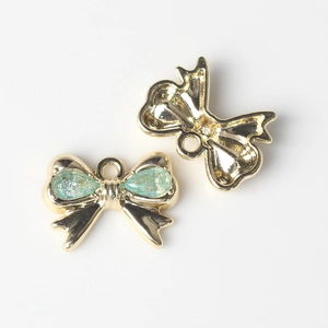 Detalle macro de colgantes de lazo con circón verde para creación de joyas DIY