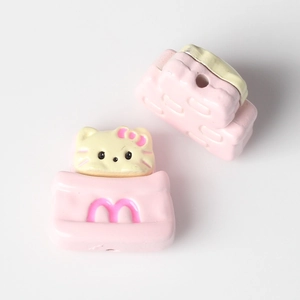 Macro view of Hello Kitty style cat bead with pink M logo for DIY jewelry making