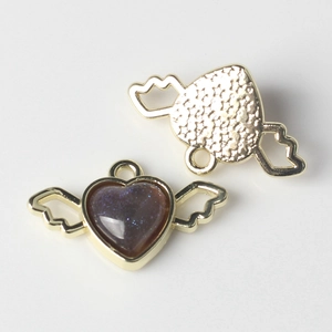 Detail showing gold heart wings pendant with sparkling purple resin and star relief