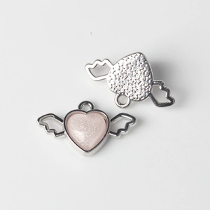 Detailed view of pink glitter heart wing charms for DIY jewelry making with front and back sides