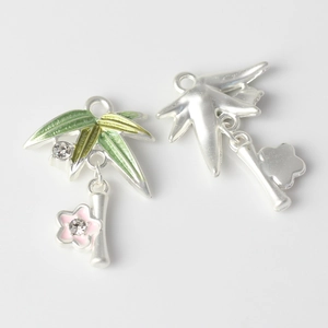Detailed close-up of alloy bamboo leaves and pink flower charms for DIY jewelry making