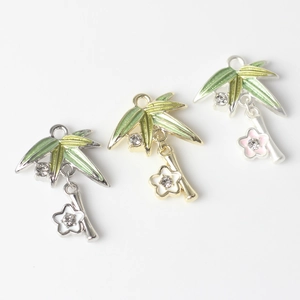 Detailed view of alloy flower and bamboo leaf charms with inlaid zircons and enamel