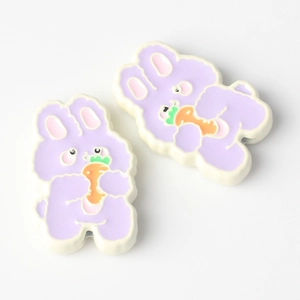 Detail of cute purple and white bunny charms with carrot accents for DIY jewelry making