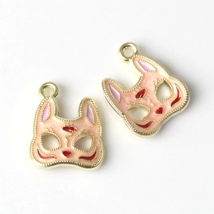 Macro detail of Japanese style fox mask alloy pendants with pink and red enamel glaze