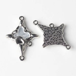 Macro detail of alloy cross connector with resin inlay and star texture for DIY jewelry