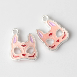Close-up of fox mask pendants with pink enamel coating and rope texture edges