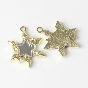 Macro detail of star pendant with mirror finish and sparkling rhinestones inlay
