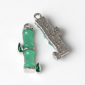 Detailed close-up of bamboo charm with green enamel inlay and star textured metal back