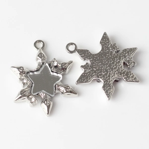 Detailed macro view of front and back snowflake charms with resin star and crystal stones