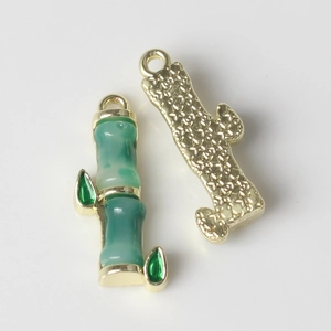 Detail of bamboo shaped gold and emerald green charms with star pattern engraving