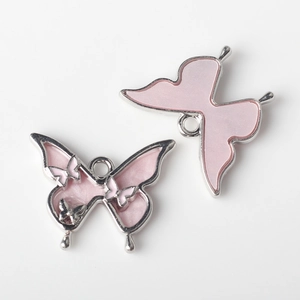 Makroaufnahme der Schmetterlingsanhänger aus Silberlegierung und rosa Emaille für DIY