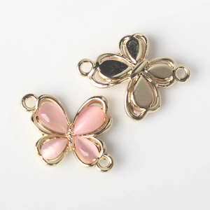 Detailed view of alloy butterfly connector charms with pink resin stones for DIY jewelry