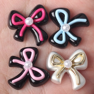 DIY colorful bow beads with pearls for jewelry making, held in hand for size comparison