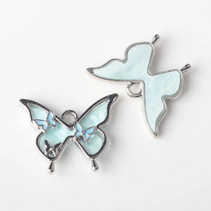Detailansicht der hellblauen Schmetterlingsanhänger mit Silberbasis für DIY Schmuck