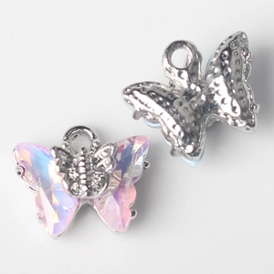 Macro view of pink crystal butterfly charms with silver frames for DIY jewelry