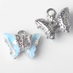 Macro shot of silver butterfly pendants with iridescent blue crystals for jewelry making