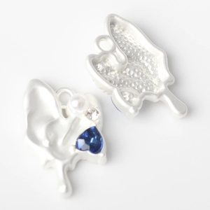 Detail of alloy heart charms with blue gemstone and pearl for DIY jewelry making