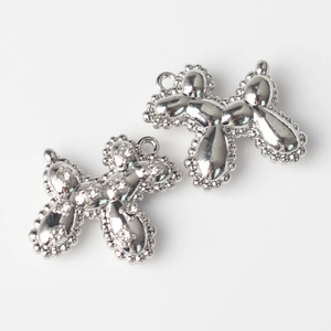 Detailed macro view of balloon dog charms featuring polished silver and zircon pavé settings