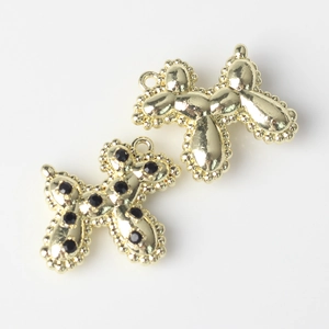 Detailed close-up of golden balloon dog pendant charms with black cubic zirconia for DIY jewelry