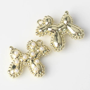 Detail of golden alloy balloon dog pendants with pearl inlay and beaded edges for DIY jewelry