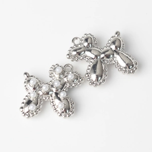 Macro shot of two silver balloon dog charms with pearl inlay for DIY jewelry design