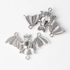 Detailed view of alloy bat connector pendants with wings and polished silver finish