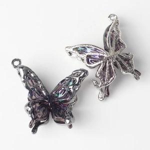 Detailed macro view of two silver butterfly pendants with iridescent purple resin wings