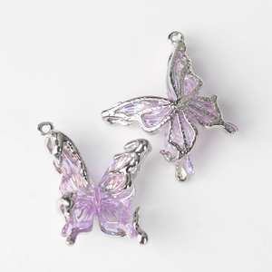 Close-up of lavender resin butterfly charms with silver metal edges for DIY jewelry making