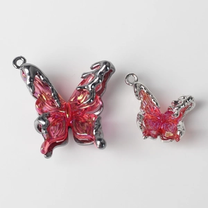 Detail of red resin butterfly charms with silver fluid metal frames for DIY jewelry