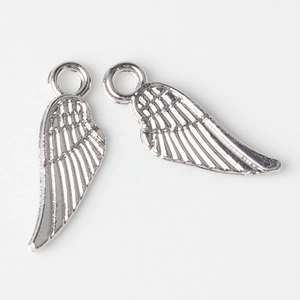Macro detail of polished silver alloy wing pendants with textured feather design for DIY jewelry