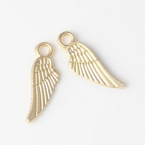 Detail of golden alloy feather charms with intricate embossed wing textures for DIY jewelry