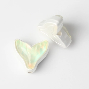 Detail of mermaid tail charms with iridescent green resin inlay for DIY jewelry making