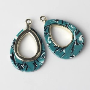 Detailed macro view of teardrop marble resin pendant with gold metal frame for DIY jewelry