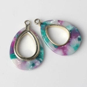 Macro shot of colorful marble resin teardrop pendants with gold metal frames for DIY jewelry