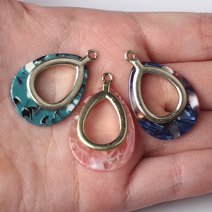 Three teardrop marble resin pendants in green pink and blue with gold alloy frames