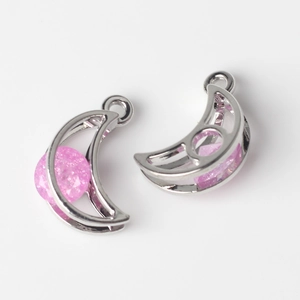 Detailed view of crescent moon pendants with pink glitter stones for DIY jewelry