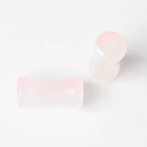 Detailed view of light pink translucent saddle ear plugs with smooth polished finish