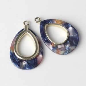 Macro detail of teardrop marble resin pendants with gold alloy frame for DIY jewelry