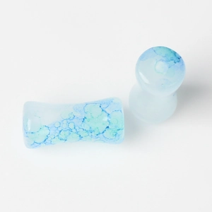 Detailed view of blue and white marble pattern glass ear plugs with polished finish