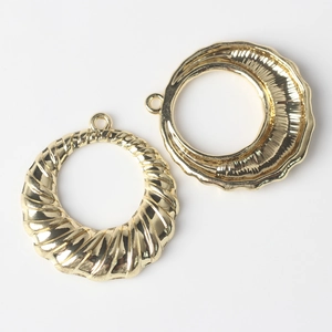 Détail de pendentifs circulaires dorés à texture spirale pour la création de bijoux DIY