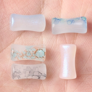 Bamboo-style painted glass saddle ear plugs in various colorful marbled patterns