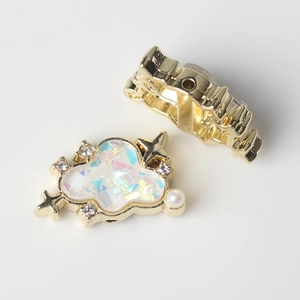 Detalle de colgante de nube dorada con resina iridiscente, perla blanca y mini cristales