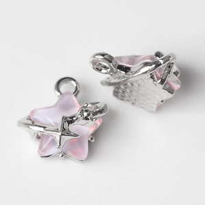 Makroansicht von sternförmigen Anhängern aus rosa Harz mit Silberrahmen für DIY-Schmuck