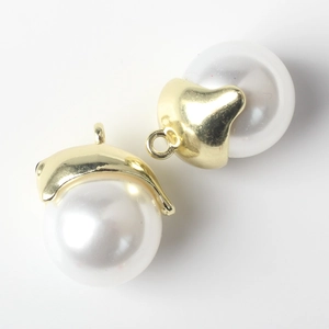 Close-up of DIY pearl ghost charms with golden metal caps for jewelry making